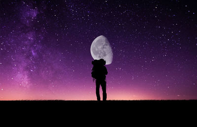 Silhouette of woman standing on field at night