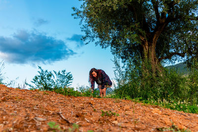 Woman standing on field against sky