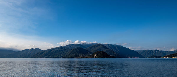 Scenic view of lake by mountains against sky