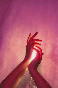 Close-up of woman hand on red wall