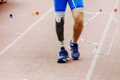 Low section of man walking on road