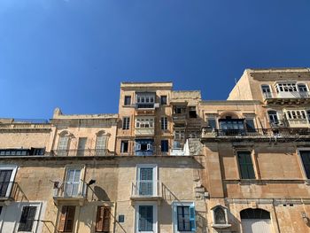 Low angle view of buildings against blue sky