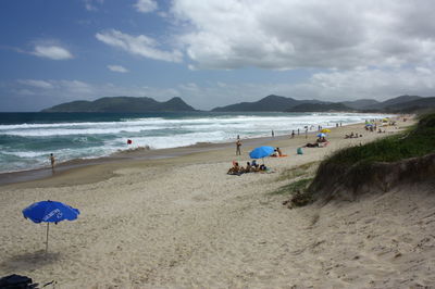 Group of people on beach against sky