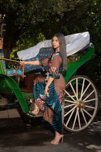 Full length of woman with umbrella standing against plants