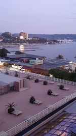 High angle view of illuminated buildings by sea against sky