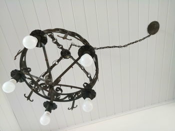 Low angle view of electric lamp hanging on ceiling