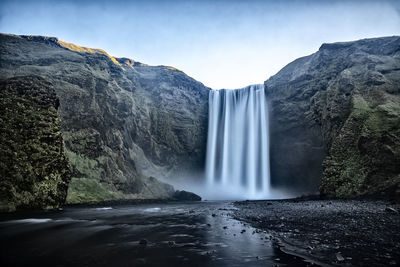 Low angle view of waterfall against sky