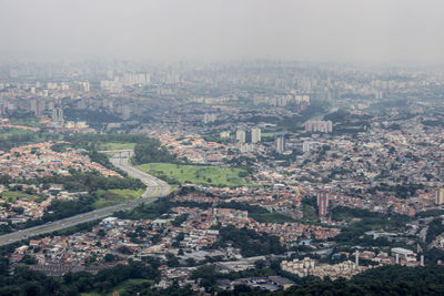 Aerial view of cityscape against sky during foggy weather