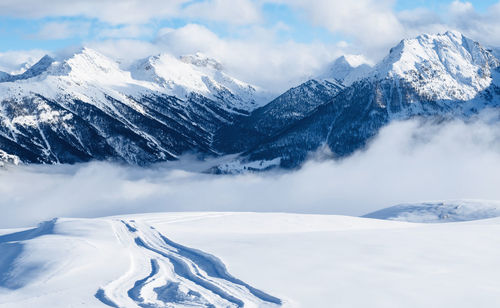 Mountain ski resort. snowcat trail on snow slope. snowy mountains. ski resort landscape 