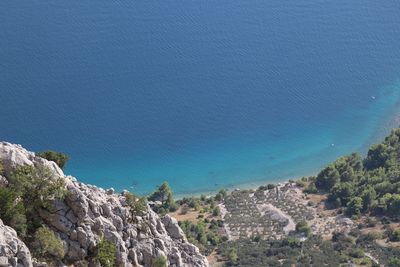 High angle view of landscape and sea against blue sky