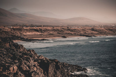 Scenic view of sea and mountains against sky