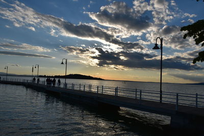 Pier over sea against sky during sunset