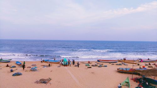 Panoramic view of people on beach against sky