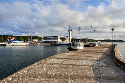 Sailboats moored at harbor against sky