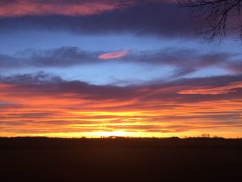 Scenic view of silhouette landscape against orange sky