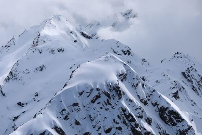 Aerial view of snow covered mountains against sky