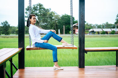 Side view of woman sitting on seat at playground