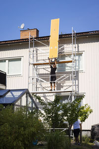 Men on scaffolding renovating house