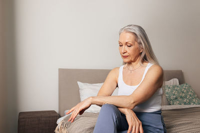 Young woman sitting on sofa at home