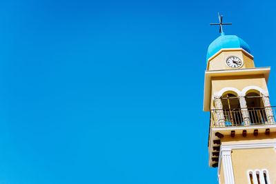 Low angle view of clock tower against clear blue sky