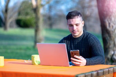 Young man using smart phone at park