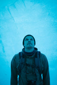 Portrait of young man standing against blue sky