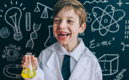 Boy wearing lap coat while standing in classroom