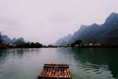 Scenic view of lake by mountains against sky