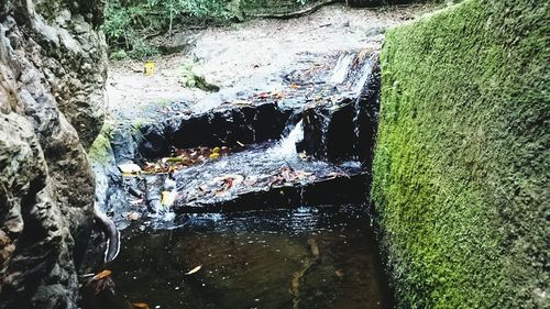 High angle view of stream flowing through rocks