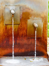 Close-up of water falling from pipe against wall