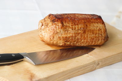 Close-up of bread with knife on cutting board