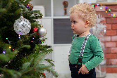 Portrait of cute girl playing with christmas tree