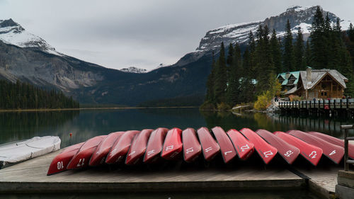 Canoes arranged on pier by lake