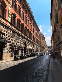 Street amidst buildings against sky in city