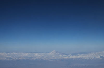 Scenic view of snowcapped mountains against blue sky