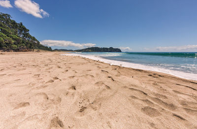 Scenic view of beach against blue sky