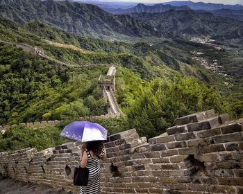 High angle view of woman carrying umbrella at great wall of china