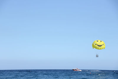 Low angle view of person paragliding against clear sky