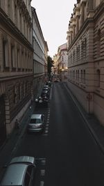 Cars on road amidst buildings against sky in city