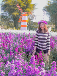 Portrait of woman standing on pink flowering plants