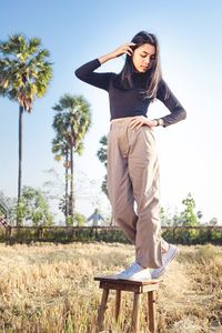 Full length of young woman standing on field