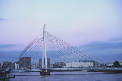 Suspension bridge over river against sky