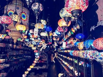 Illuminated lanterns hanging at market stall