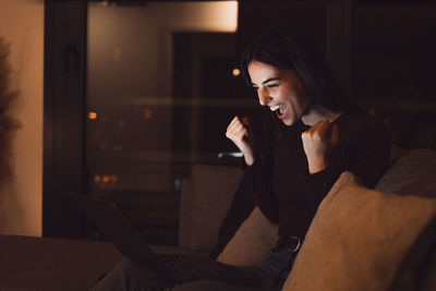 Young woman looking away while sitting at home