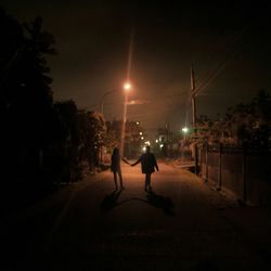 Silhouette people on illuminated city at night