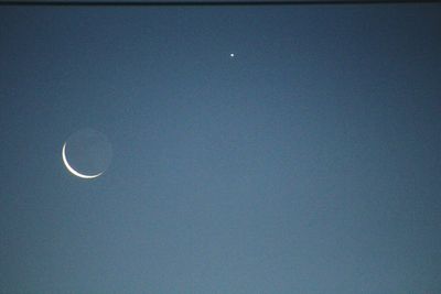 Low angle view of moon against blue sky