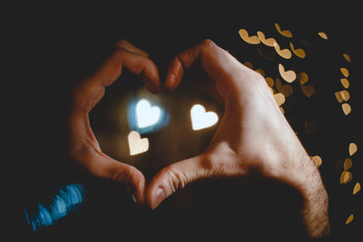 Close-up of human hand against black background