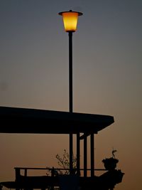 Low angle view of illuminated street light against sky at sunset