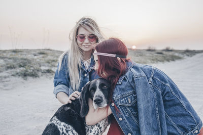 Portrait of young woman with dog at beach