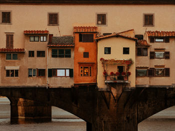 Buildings by river against sky in city